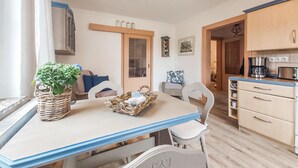 Une cuisine chaleureuse avec une table à manger, des chaises et une machine à café.