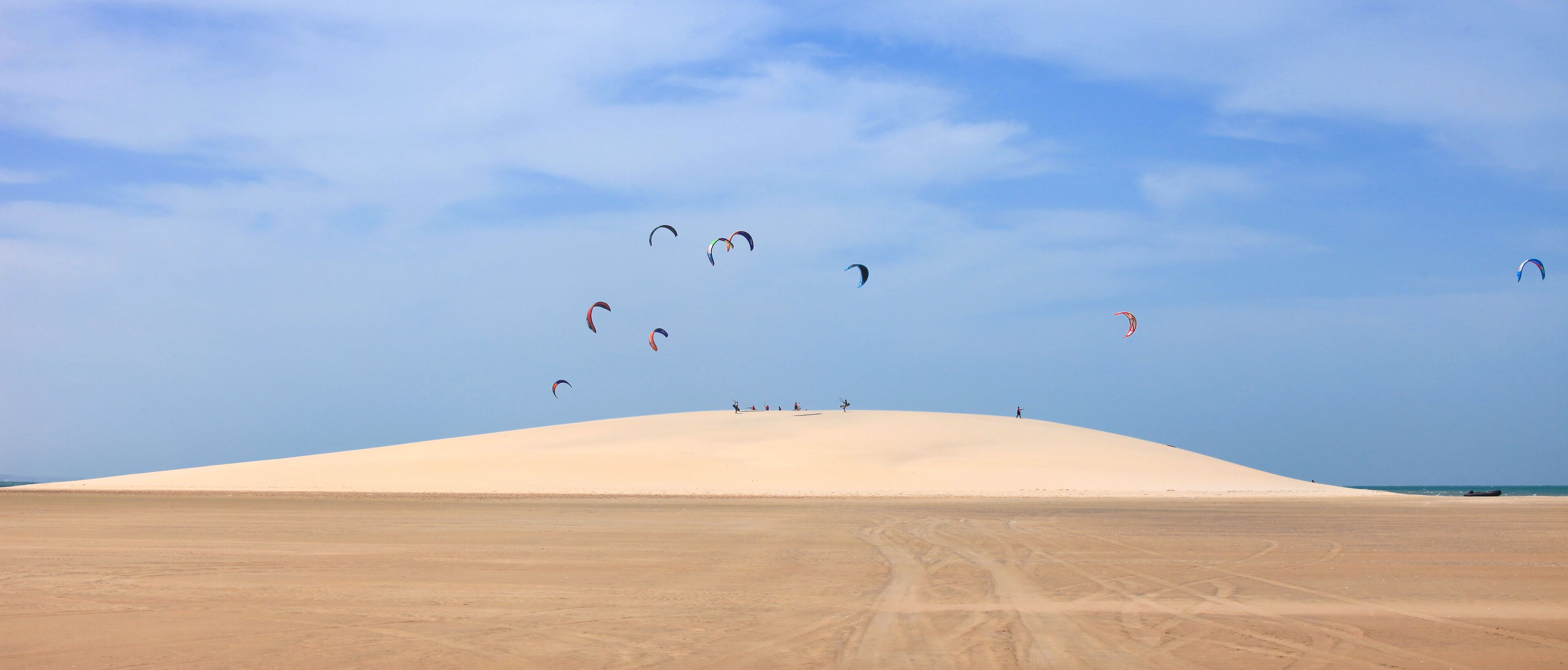 Un paysage désertique avec des dunes de sable et un ciel dégagé.