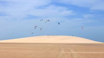 Un paysage désertique avec des dunes de sable et un ciel dégagé.
