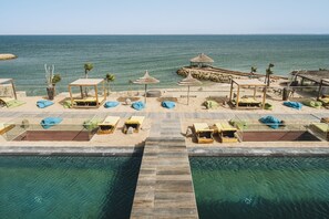 Una piscina al aire libre, sillones reclinables de piscina