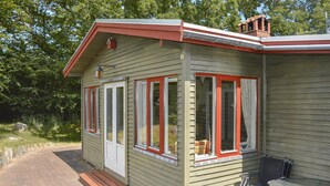 Un petit bâtiment d’un seul étage, doté d’un porche, d’une porte et de fenêtres aux cadres rouges.