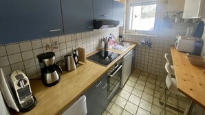 A kitchen with blue cabinets, a window, a sink, and a wooden countertop. - beautiful, very quiet apartment with terrace  (Winterberg)