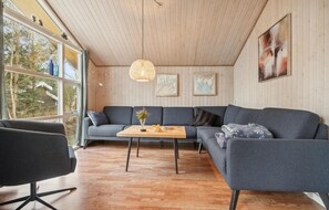 Relax in this serene space with a view of the surrounding trees and landscape from the large window.