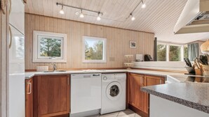 A modern kitchen with wooden cabinets, a dishwasher, and a large window providing natural light. - Stunning home in Fjerritslev with WiFi (Fjerritslev)