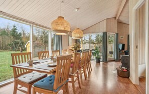 Enjoy meals in this stylish dining area with a wooden table and chairs, a mounted TV, and a sofa.