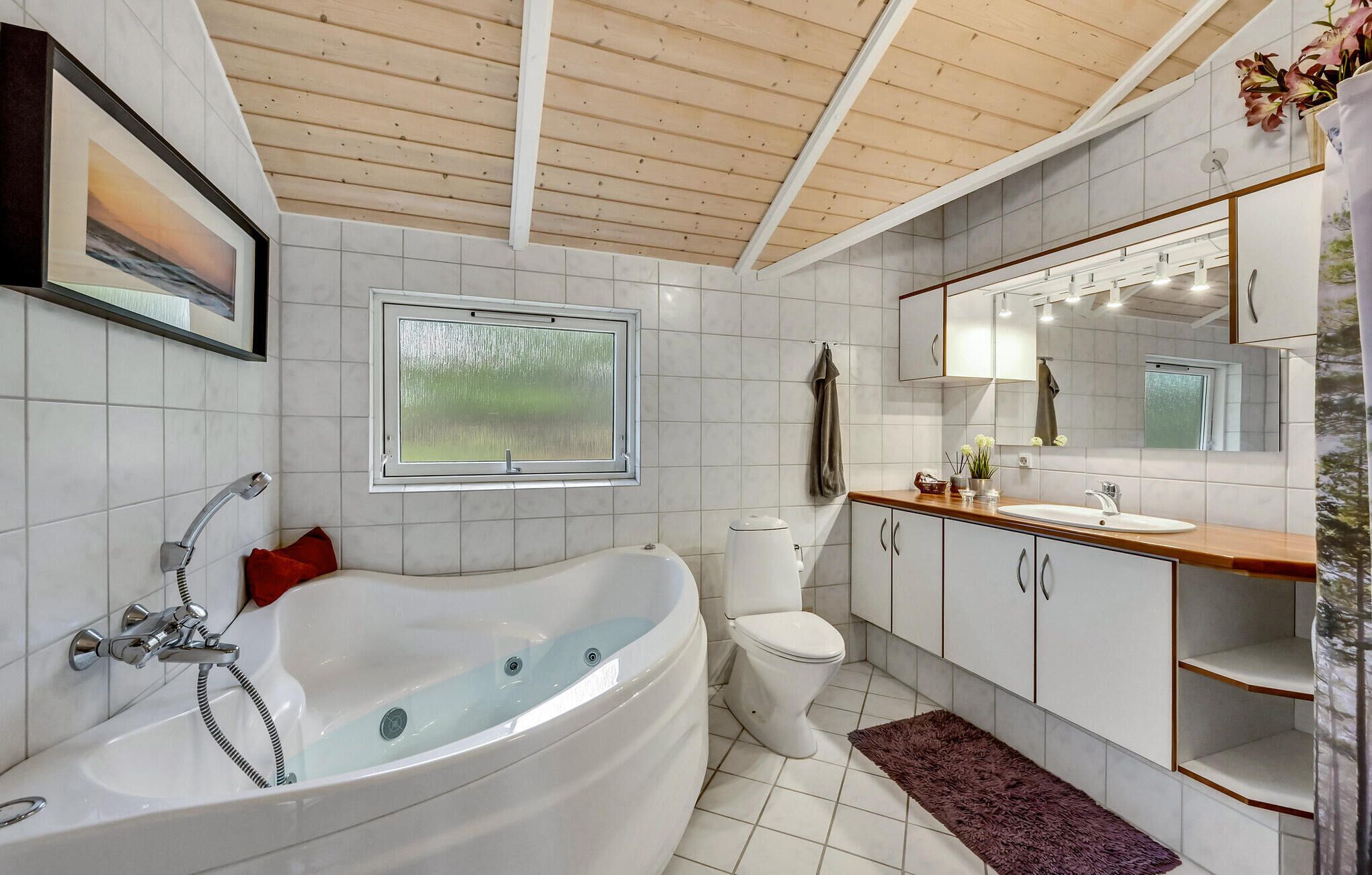 A modern bathroom with a freestanding bathtub, a toilet, a sink, and a large mirror.