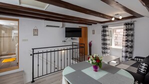 A modern living room with a glass table, black and white patterned sofa, and a wooden ceiling. - Old Town Charming Nest (Dubrovnik)