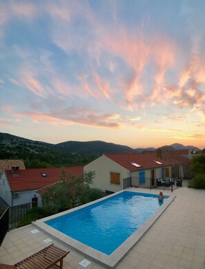 Una piscina con vista su case e montagne sullo sfondo.
