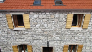 A stone building with three windows, each with wooden shutters. - Holiday Home Stari Zoganj (Orebic)