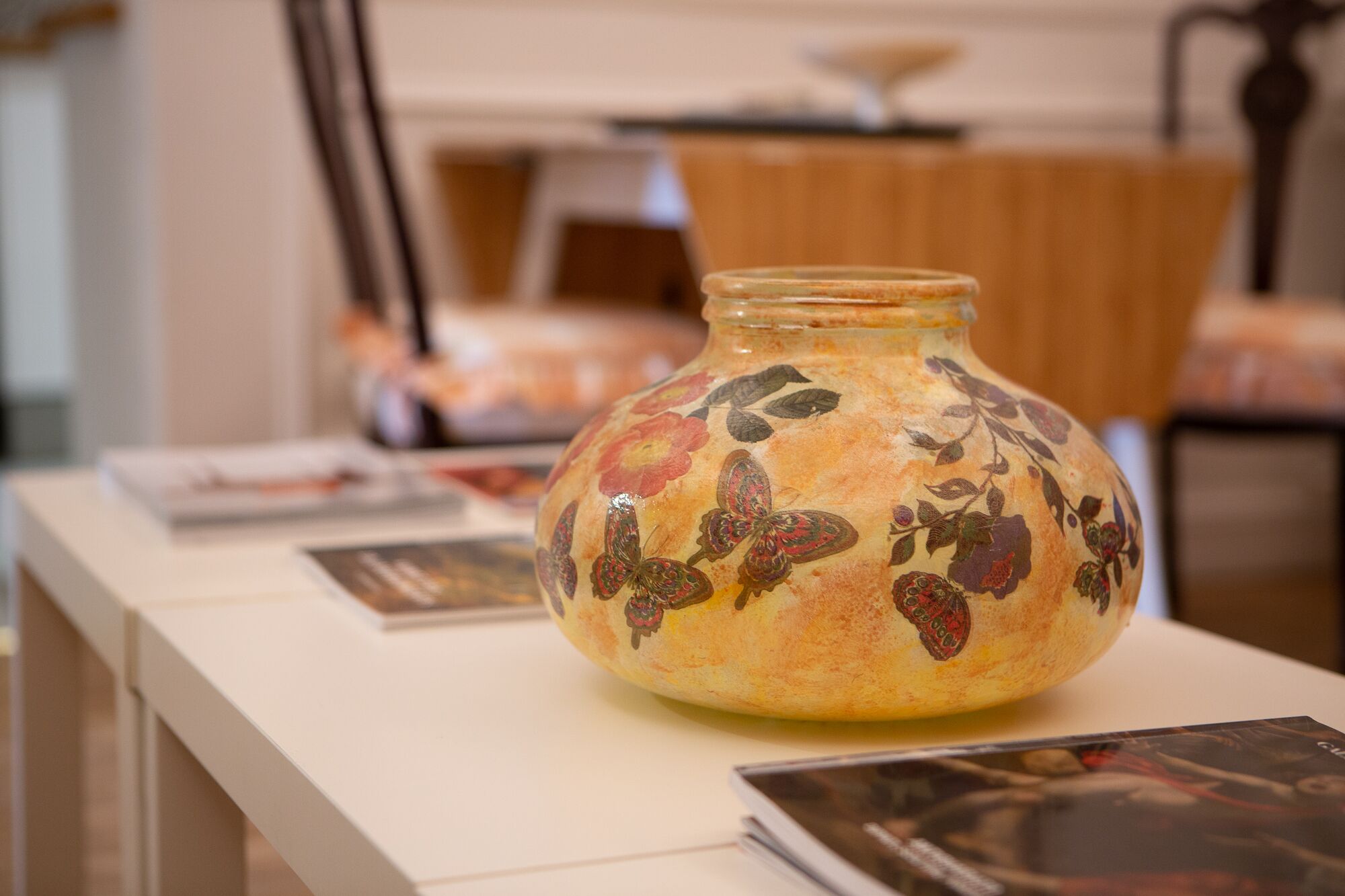 A vase with floral patterns on a table.