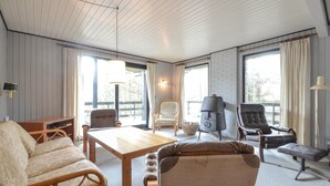 A cozy living room with a wooden table, two armchairs, a sofa, and a grill. - Amazing home in Hurup Thy with WiFi (Hurup Thy)