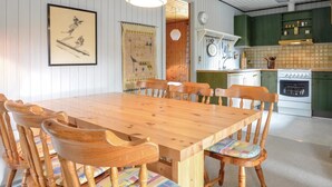 A wooden dining table with six chairs, a kitchen with green cabinets, and a framed picture on the wall. - Amazing home in Hurup Thy with WiFi (Hurup Thy)