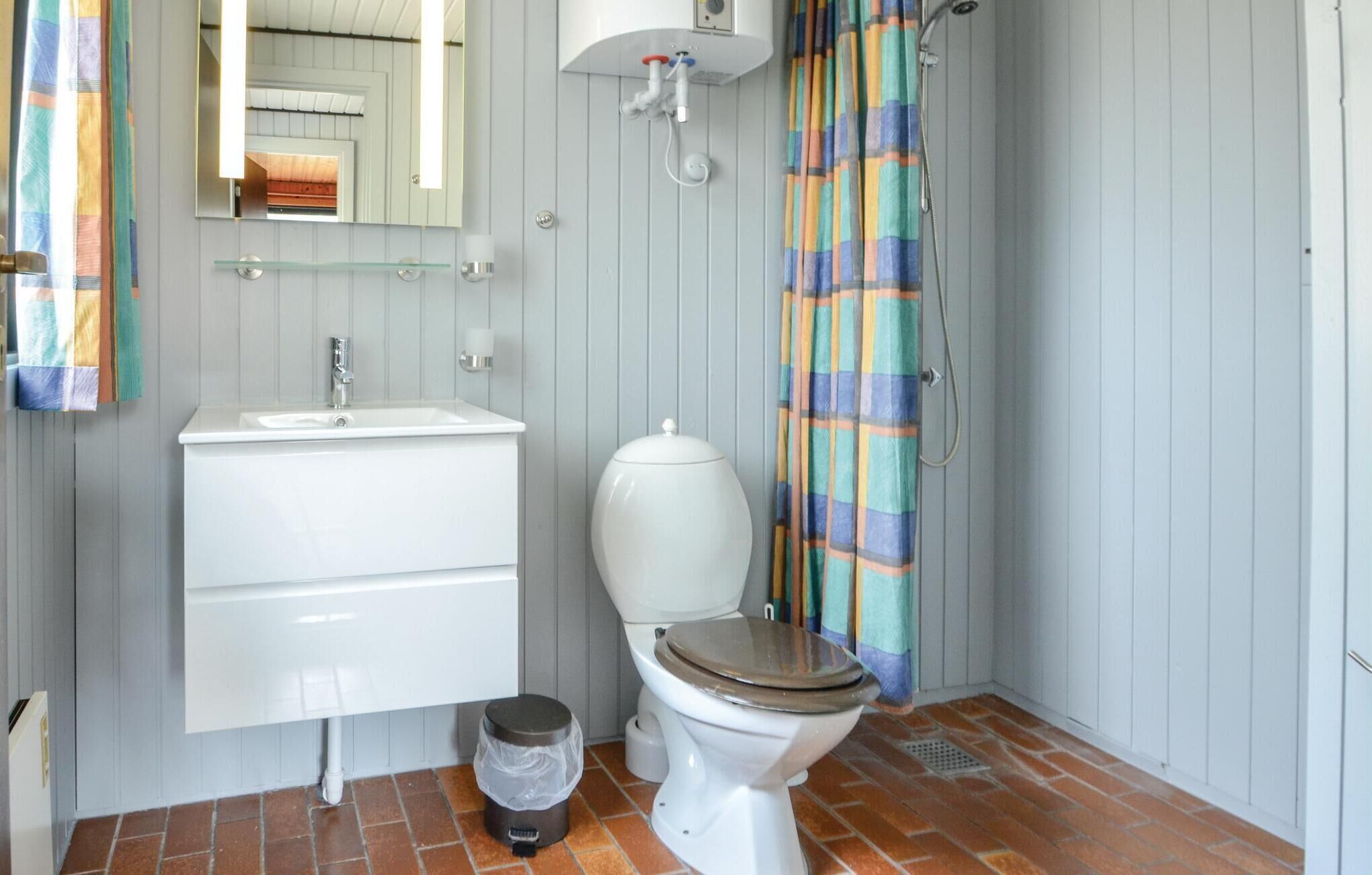Un baño con lavamanos blanco, inodoro y cortina de ducha.