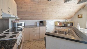 A compact kitchen with a stove, microwave, and refrigerator. - 3 bedroom awesome home in Thisted (Thisted)