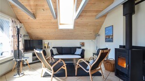 A cozy living room with a sofa, two chairs, a small table, a fireplace, and a TV. - 3 bedroom awesome home in Thisted (Thisted)