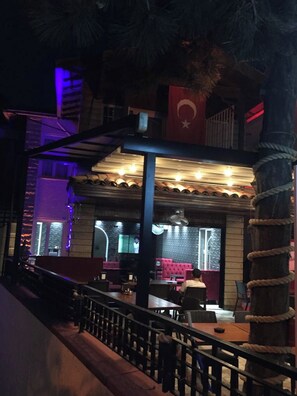 A restaurant with a view of a building, a flag, and a staircase. - Gorkemli Hotel (Adalar)