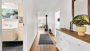 Eine moderne Küche mit weißen Schränken, einer Holz Arbeitsplatte und einem großen Spiegel.