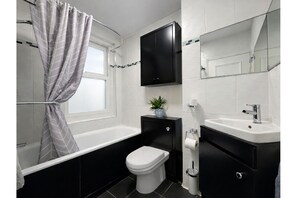 Une salle de bain moderne avec une baignoire, des toilettes et un lavabo.