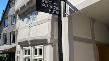 Ein Hotelschild für 'WERT SCHÄTZER HOTEL' an der Gebäudefassade.