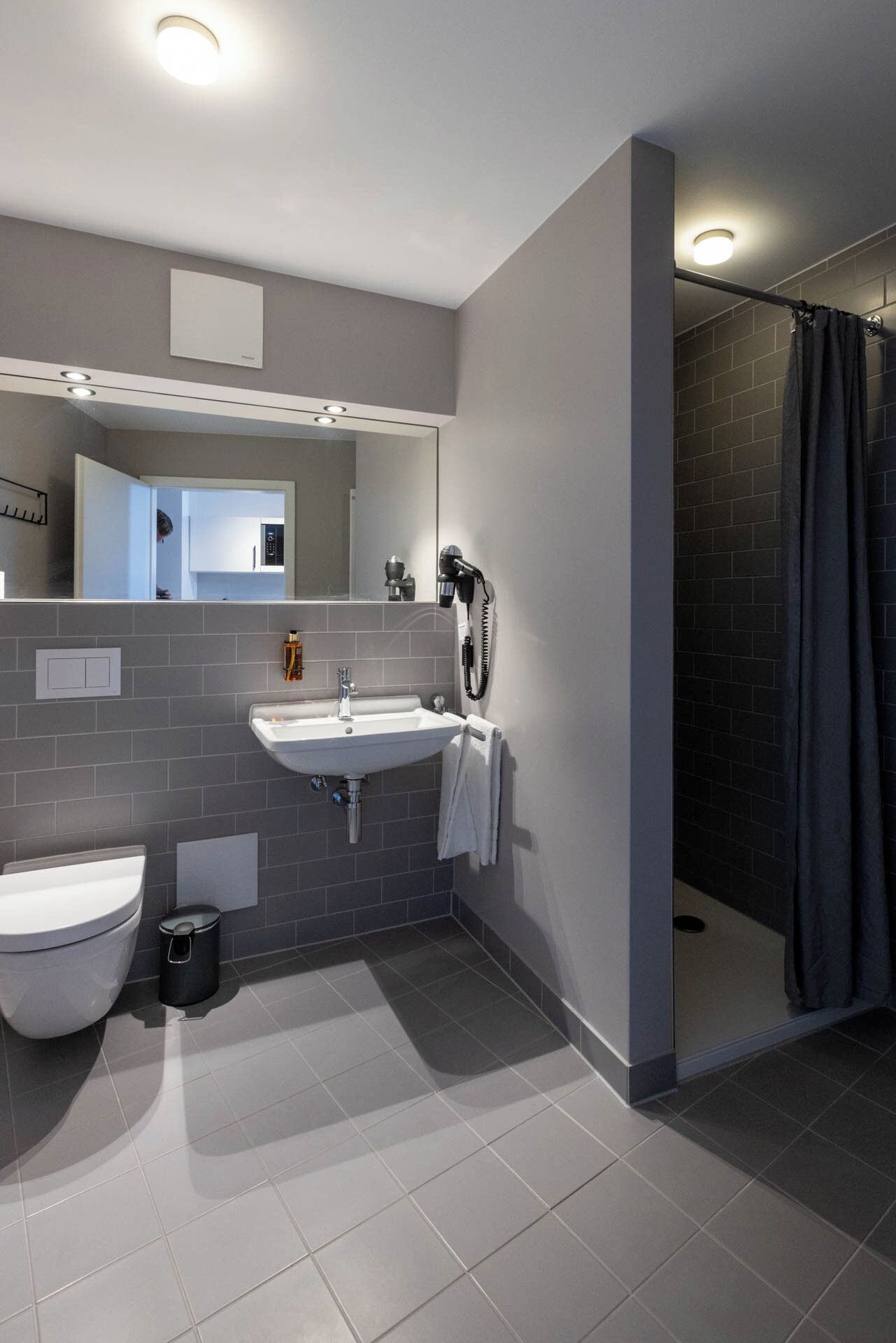 A modern bathroom with a toilet, sink, and shower.