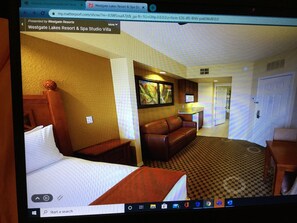 Relax in this cozy space with a large bed, comfortable sofa, and a stylish lamp.