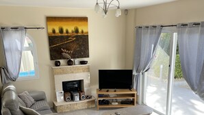Een moderne woonkamer met een open haard, een flatscreen televisie en een zithoek.