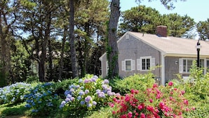 A house with a grey exterior, white shutters, and a brick chimney. - Spacious, private cottage just a few minutes walk to Ridgevale Beach! (Chatham)