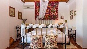 Ein traditionell eingerichteter Raum mit Bett, Baldachin und Wandteppich.