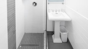 Un baño con ducha, lavabo e inodoro.