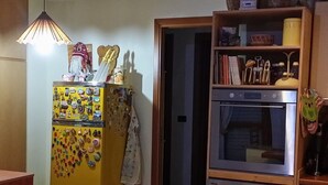Eine Küche mit einem gelben Kühlschrank, einem Backofen und einem Geschirrspüler.