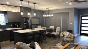 Une cuisine moderne avec un coin repas, un canapé et une table basse.