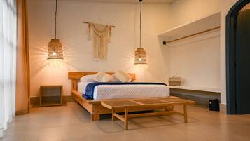 Un dormitorio con cama de madera, dos lámparas colgantes, una mesita de noche y una pequeña repisa junto a la cama.
