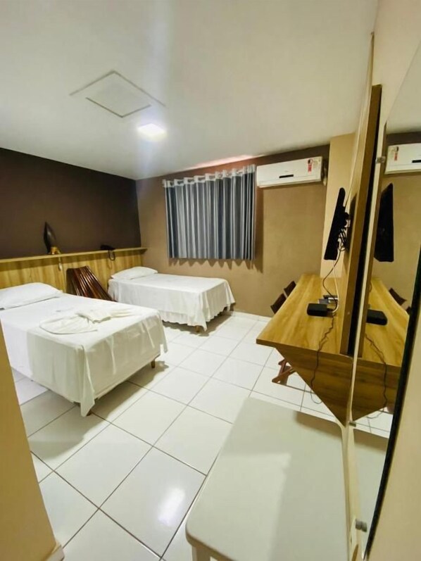 A hotel room with two beds, a desk, a chair, a mirror, and a window with curtains. - Borges Hotel (Imperatriz)