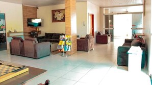 A spacious living area with sofas, a coffee table, a TV, and a pillar.
