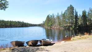 Un lac paisible où trois bateaux sont amarrés sur la rive.