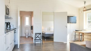 A modern, well-lit room with a kitchenette, a bathroom, and a bed. - 1 bedroom nice home in Kosta (Kosta)