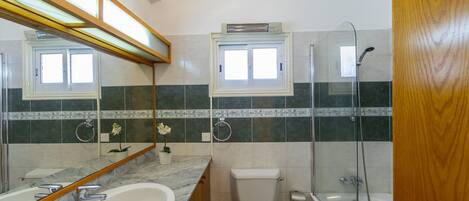 A bathroom with a sink, toilet, and shower.