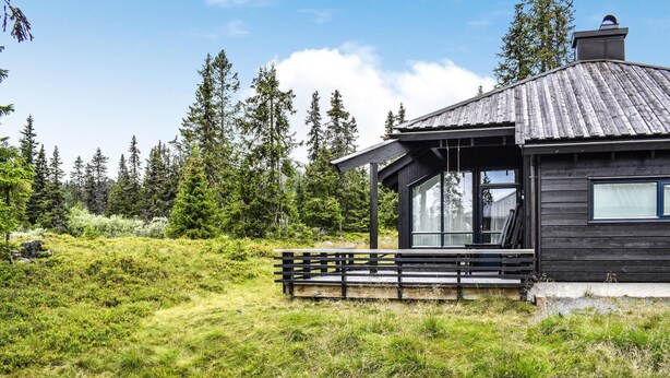 A cabin with a wooden exterior, large windows, and a porch. - Stunning home in Sjusjøen with sauna (Sjusjøen)
