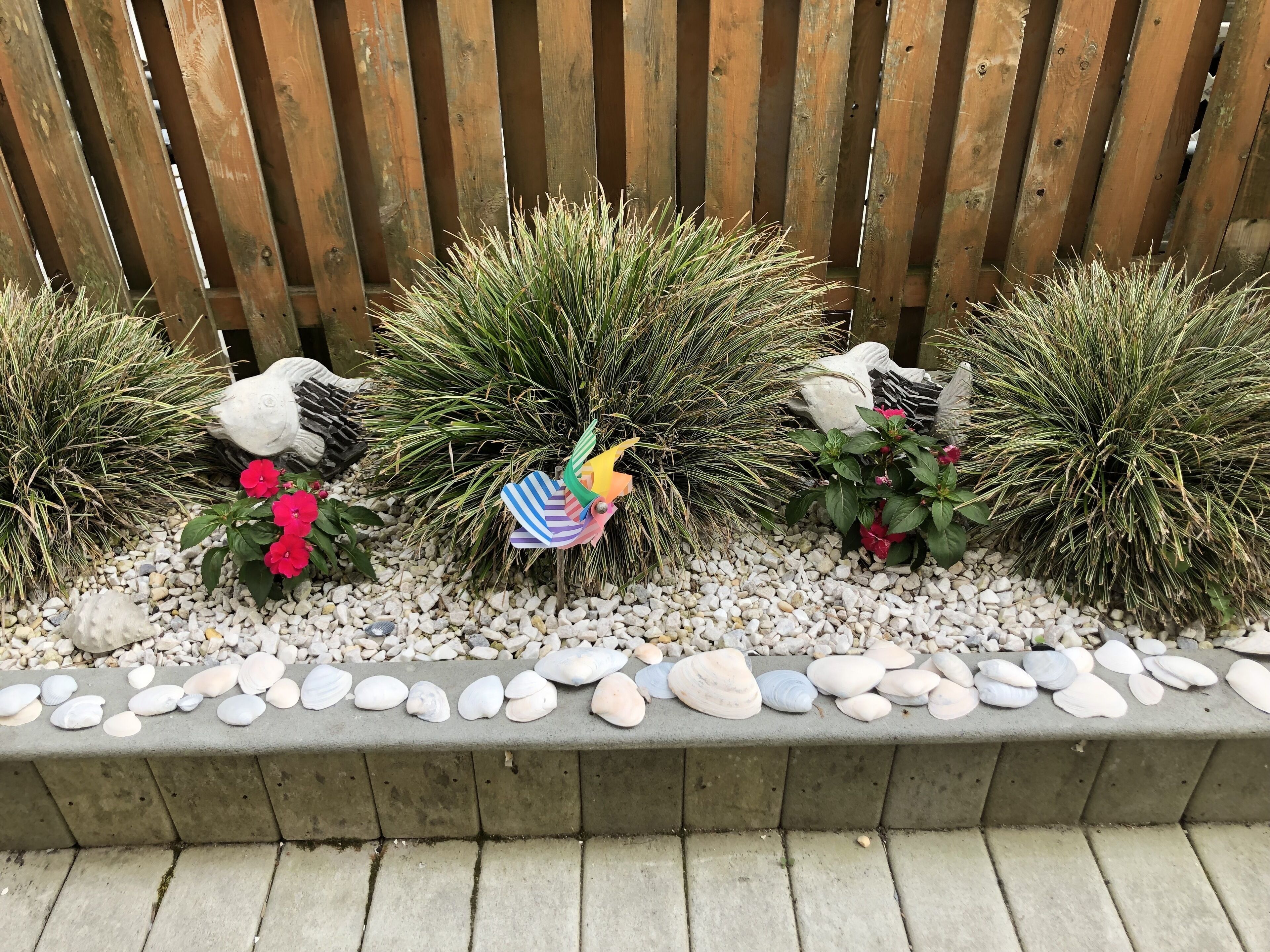 Ein Blumenbeet mit dekorativen Vogelbildnissen und Kieselsteinen.