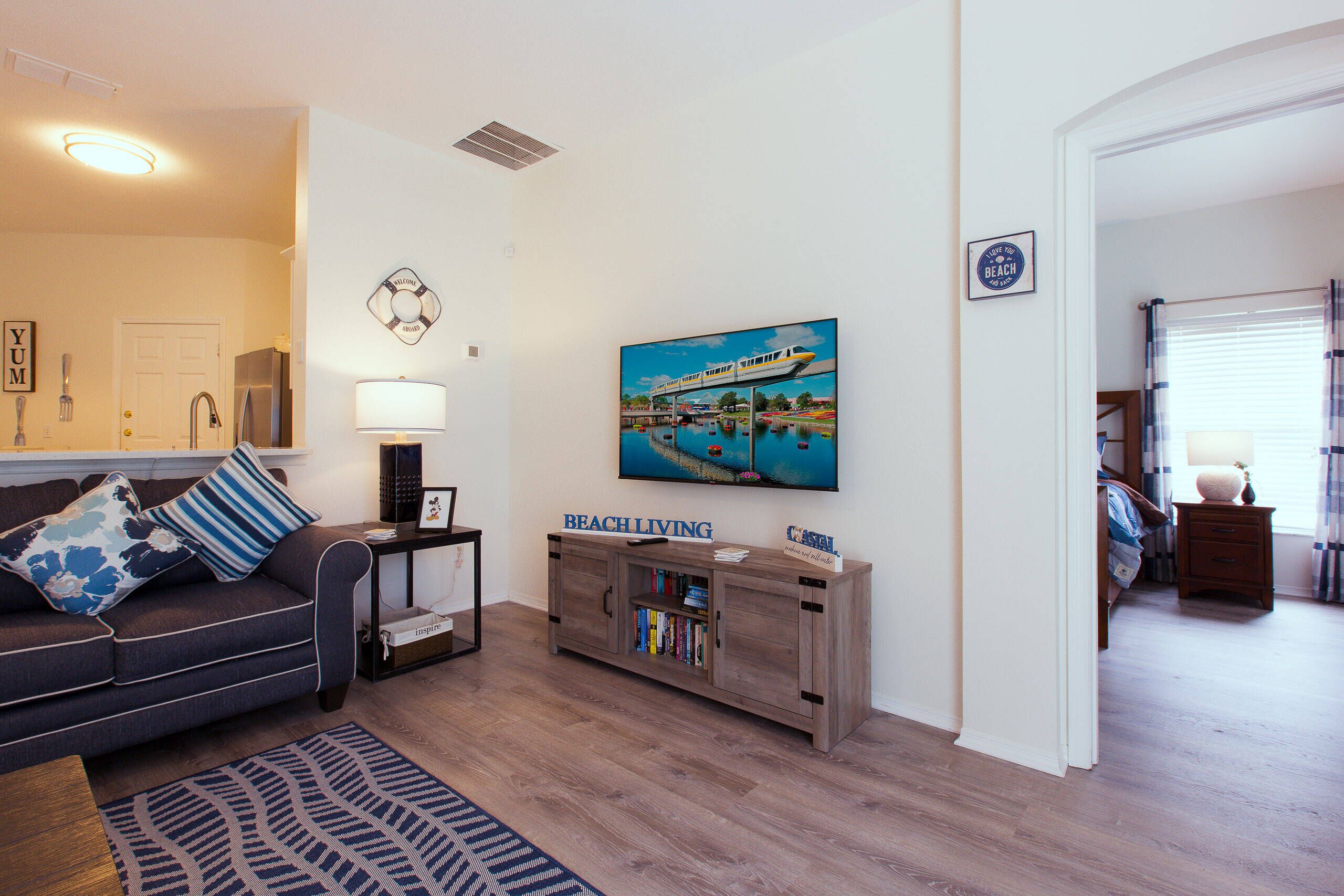 A living room with a sofa, a coffee table, a side table, a bookshelf, and a painting of a train on a bridge.