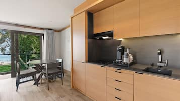 A modern kitchen with wooden cabinets, a black stove, and a coffee machine.
