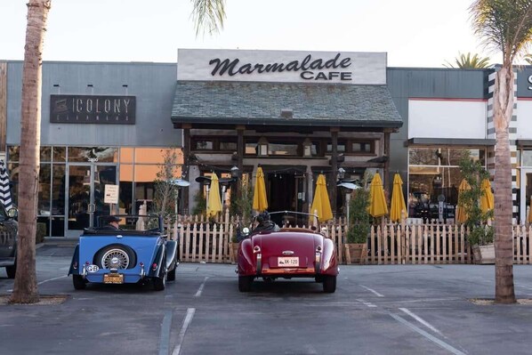A Marmalade Cafe with a vintage car parked in front.