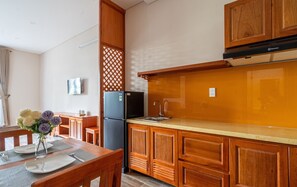 A compact kitchen with wooden cabinets, a black refrigerator, and a sink.