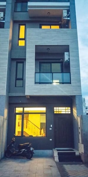 A modern multi-story building with a flat roof, large windows, and a visible entrance with a dark door. - Forest Cafe (Ji'an)