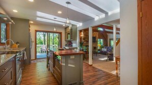 A spacious kitchen with a central island, wooden flooring, and a view of the outdoors. - Walk to Road America Races. Enjoy the lake frontage and fishing and kayaking. (Plymouth)
