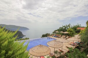Una piscina al aire libre de temporada, sombrillas