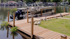 Un muelle de madera se extiende sobre un lago tranquilo, con una embarcación amarrada al final.