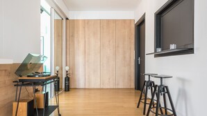 Un interior moderno con piso de madera, un escritorio con una laptop y dos taburetes de bar.
