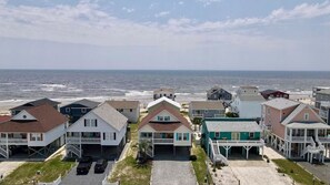 A coastal residential area with houses featuring front porches and a view of the ocean. - 3rd Row-Only Steps Away from Paradise (Ocean Isle Beach)