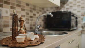 A kitchen with a coffee maker, a kettle, and a tray with cups and sugar cubes. - A home witha view Sky -attic (Mostar)